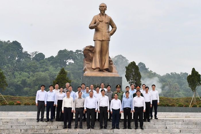 Các đại biểu chụp ảnh lưu niệm trước tượng đài Bác Hồ.