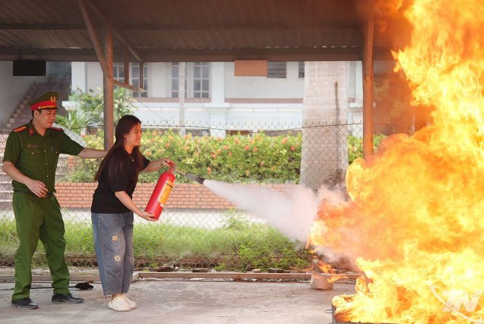 Học viên thực hành sử dụng bình chữa cháy để dập tắt đám cháy.