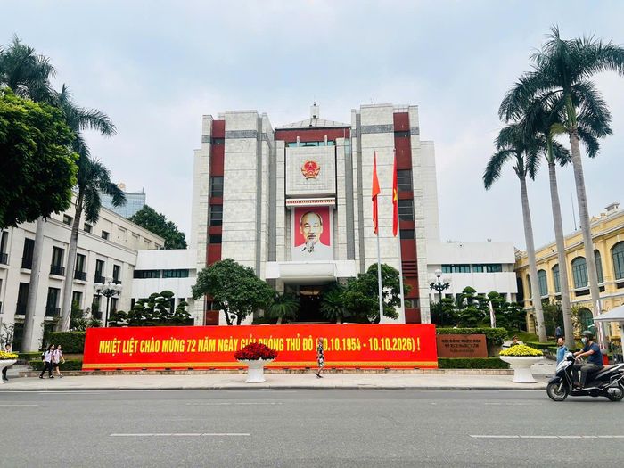Trước trụ sở UBND thành phố Hà Nội bên hồ Hoàn Kiếm, cờ Tổ quốc tung bay cùng pano mang dòng chữ “Nhiệt liệt chào mừng 72 năm Ngày Giải phóng Thủ đô (10/10/1954 - 10/10/2026)”. Hình ảnh tạo điểm nhấn trang trọng tại khu vực trung tâm, thể hiện sự chuẩn bị chu đáo của thành phố hướng tới ngày lễ có ý nghĩa đặc biệt đối với người dân Thủ đô.