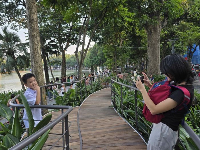 Hai mẹ con này thì có cả trăm kiểu ảnh trên cây cầu. Cậu bé háo hức bảo mẹ: "Cầu này đẹp thế, mẹ chụp ảnh cho con". Còn người mẹ thì chia sẻ: Đây là một cây cầu đi bộ cảnh quan. Nó được thiết kế thân thiện với không gian. Nó cũng góp phần làm tươi mới, làm khác đi cách mà mẹ con tôi cảm nhận không gian vốn quen thuộc này".