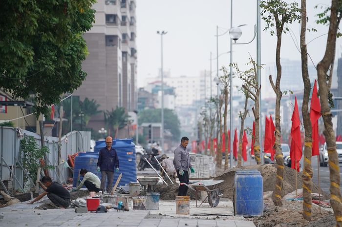 Trong khi tuyến đường đã được thông xe, công nhân vẫn tiếp tục hoàn thiện vỉa hè và các hạng mục phụ trợ ở cuối tuyến Cầu Giấy - Dương Đình Nghệ.