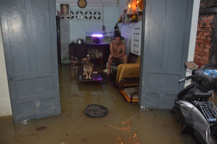 Nước dâng cao, người dân phải kê đồ đạc và ngồi lên cao.