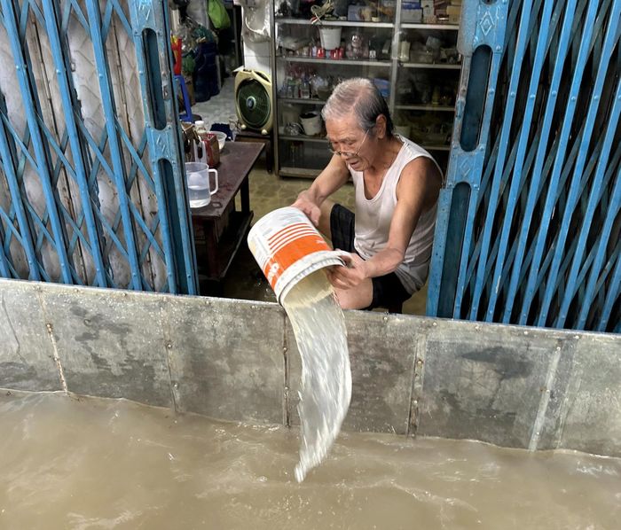 Người dân tát nước ra khỏi nhà trong đợt triều cường "lịch sử".