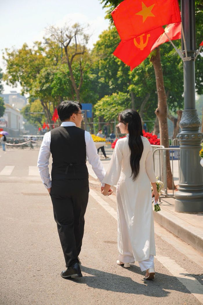 Cặp đôi Nguyên Vũ - Thanh Bình (Hà Nội) lựa chọn không gian rợp cờ hoa tại phố đi bộ để lưu giữ khoảnh khắc hạnh phúc của đời mình.