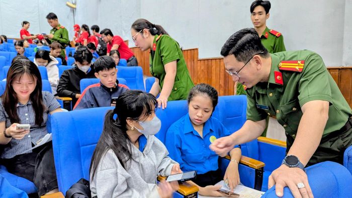 Lực lượng Công an tuyên truyền và trực tiếp hướng dẫn các sinh viên tích hợp các loại giấy tờ cơ bản lên ứng dụng VNeID. Ảnh: Nghiêm Túc
