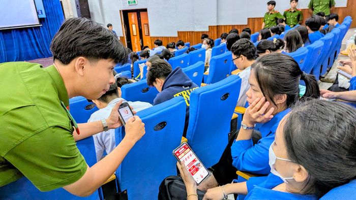 Cán bộ Công an hướng dẫn các sinh viên tích hợp các loại giấy tờ cơ bản lên ứng dụng VNeID. Ảnh: Nghiêm Túc