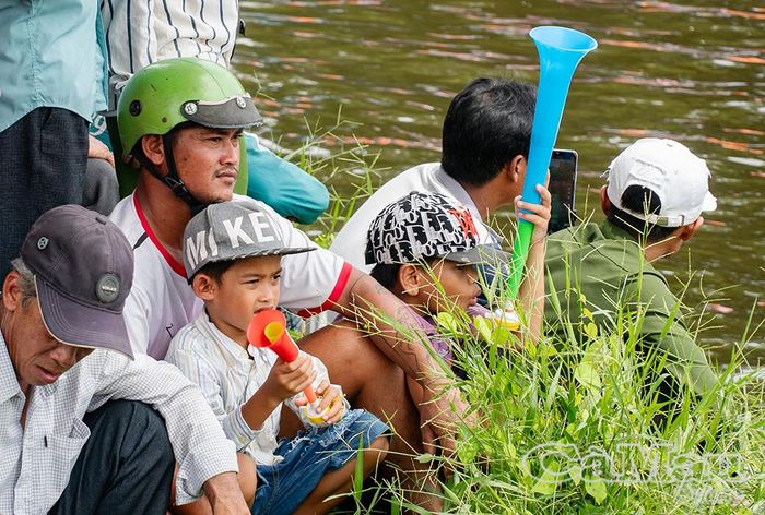 Các em nhỏ dùng kèn cổ vũ các đội đua.