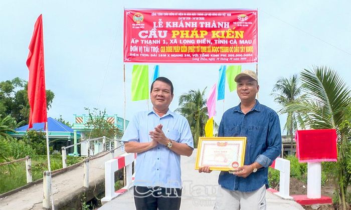 Đồng chí Nguyễn Nam Quân, Bí thư Đảng uỷ xã Long Điền, trao Bằng khen của Uỷ ban MTTQ Việt Nam tỉnh Cà Mau cho ông Trịnh Minh Tuấn.