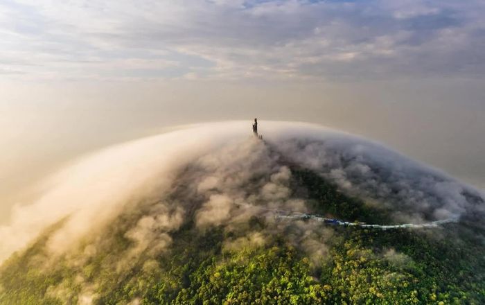 Tượng Phật Bà Tây Bổ Đà Sơn ẩn hiện giữa biển mây mang đến không gian tâm linh thiêng liêng và huyền ảo.