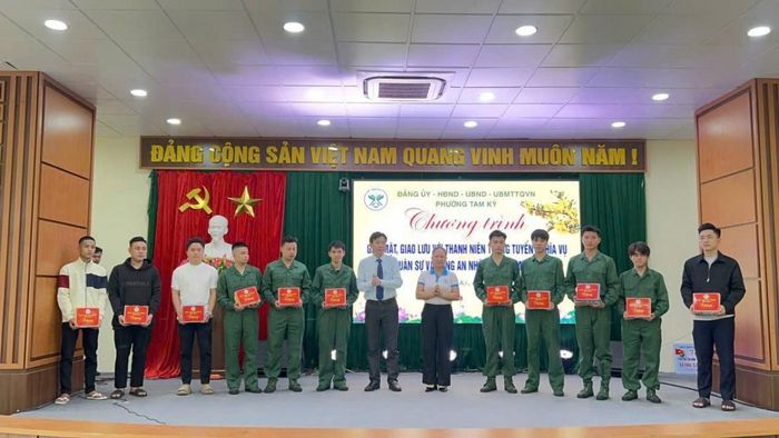 Ông Đỗ Văn Minh, Chủ tịch UBND phường Tam Kỳ (đứng giữa), trao quà động viên thanh niên trúng tuyển nghĩa vụ quân sự và nghĩa vụ tham gia Công an nhân dân năm 2026.