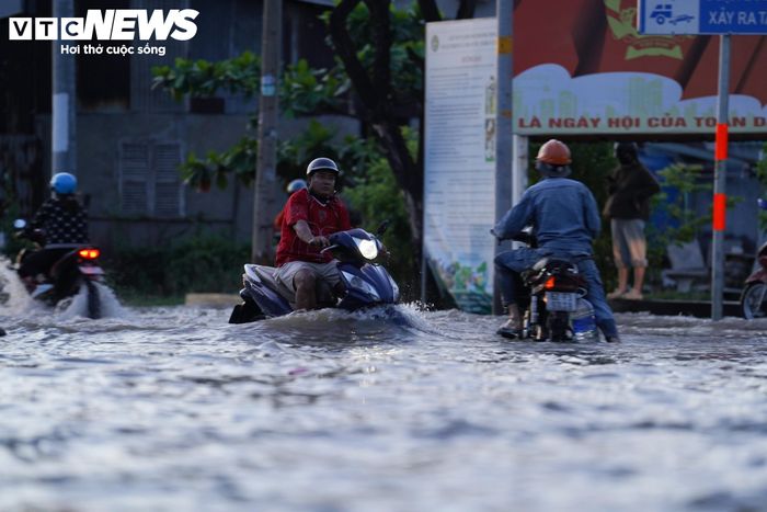 Do mực nước ngập cao, người đi đường khó phân biệt ranh giới giữa mặt đường và lề đường. Không ít người loay hoay tìm cách di chuyển qua vùng nước sâu, thậm chí bị té ngã khi đi qua những đoạn ngập.