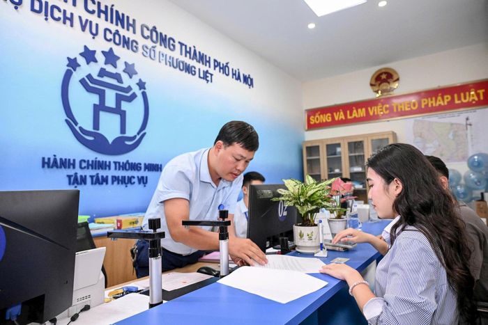 Công chức Điểm hỗ trợ dịch vụ công số Phương Liệt hướng dẫn doanh nghiệp thực hiện thủ tục hành chính. Ảnh: PV