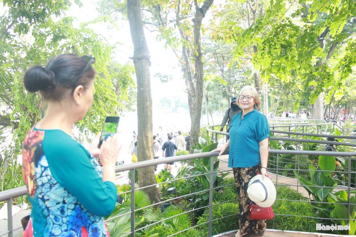 Bà Nguyễn Ngọc Ký lưu giữ khoảnh khắc tại không gian mới hồ Hoàn Kiếm. Ảnh: Vi Giáng