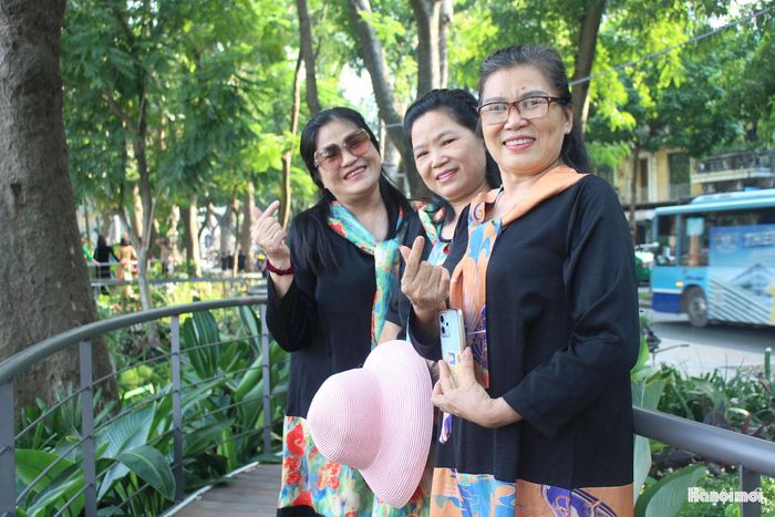 Cô Đặng Hà Châu (đứng bên phải) cùng bạn bè lưu giữ những khoảnh khắc mùa thu Hà Nội tại không gian nghệ thuật "Dải lụa ký ức". Ảnh: Vi Giáng