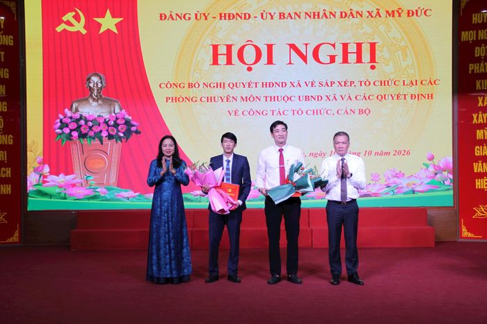 Phó Bí thư Thường trực Đảng ủy xã Nguyễn Thị Thúy Hòa và Chủ tịch UBND xã Mỹ Đức Nguyễn Quang Đường trao quyết định bổ nhiệm lãnh đạo Văn phòng Đảng ủy xã. Ảnh: Biên Phạm