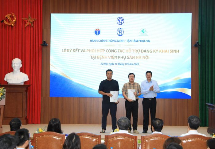 Giám đốc Trung tâm Phục vụ hành chính công thành phố Hà Nội Phan Văn Phúc trao Giấy khai sinh, chia sẻ niềm vui với các gia đình sản phụ. Ảnh: Linh Chi