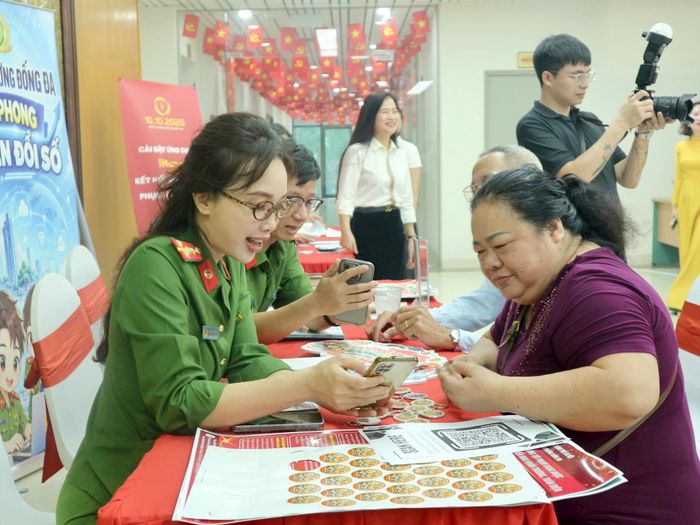 Công an phường hỗ trợ người dân cài đặt ứng dụng VNeID. Ảnh: T.H