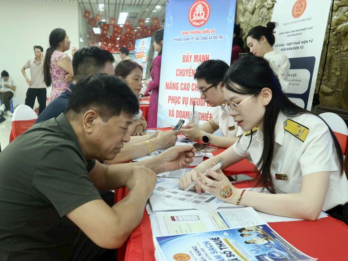 Thuế cơ sở 4 thành phố Hà Nội hỗ trợ, hướng dẫn người dân kê khai thuế. Ảnh: T.H