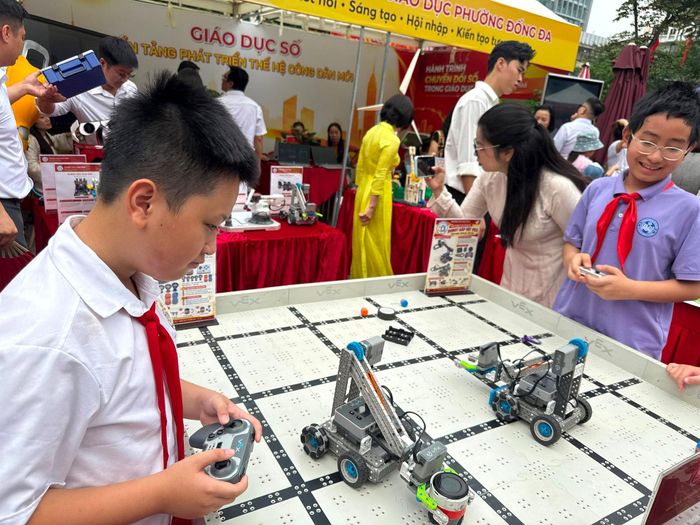 Các em học sinh trải nghiệm robotics tại sự kiện. Ảnh: T.H