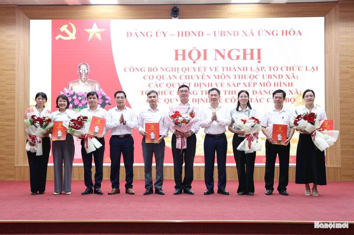 Đồng chí Đàm Văn Huân, Bí thư Đảng ủy, Chủ tịch HĐND xã Ứng Hòa và đồng chí Nguyễn Đức Bình, Phó Bí thư Đảng ủy, Chủ tịch UBND xã Ứng Hòa trao Quyết định và tặng hoa chúc mừng các Chi bộ mới thành lập. Ảnh: Mai Quý