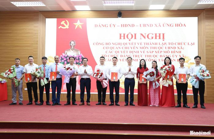 Đồng chí Đàm Văn Huân, Bí thư Đảng ủy, Chủ tịch HĐND xã Ứng Hòa và đồng chí Nguyễn Đức Bình, Phó Bí thư Đảng ủy, Chủ tịch UBND xã Ứng Hòa trao Quyết định và tặng hoa chúc mừng các Chi bộ mới thành lập. Ảnh: Mai Quý