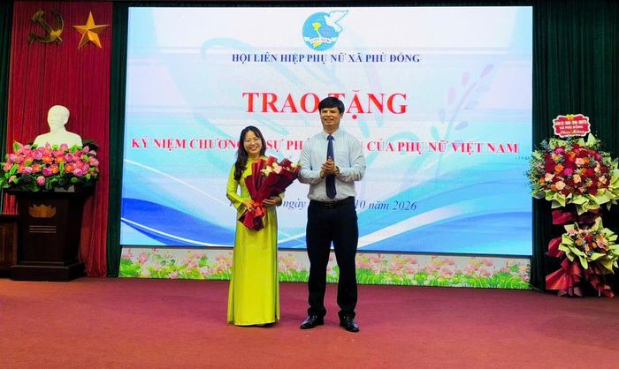 Chủ tịch UB MTTQ Việt Nam xã Phù Đổng Nguyễn Đức Thể trao tặng Kỷ niệm chương “Vì sự phát triển của phụ nữ” cho các cá nhân. Ảnh PV