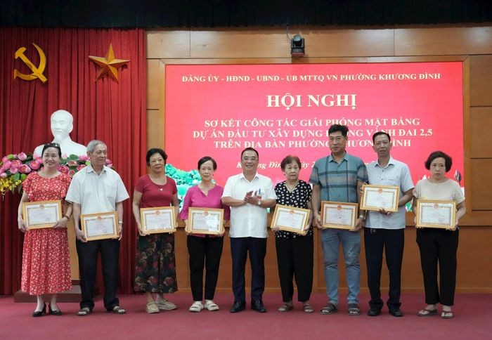 Lãnh đạo phường Khương Đình trao tặng Giấy khen cho các hộ gia đình, cá nhân có nhiều đóng góp trong công tác GPMB dự án đường Vành đai 2,5 trên địa bàn phường. Ảnh: Hồng Thái