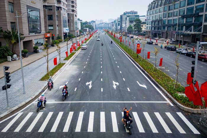  Mặt đường được thảm nhựa, kẻ vạch phân làn và lắp đặt đèn tín hiệu giao thông, giúp phương tiện lưu thông thông suốt tại đoạn Cầu Giấy - Dương Đình Nghệ trong ngày thông xe. 