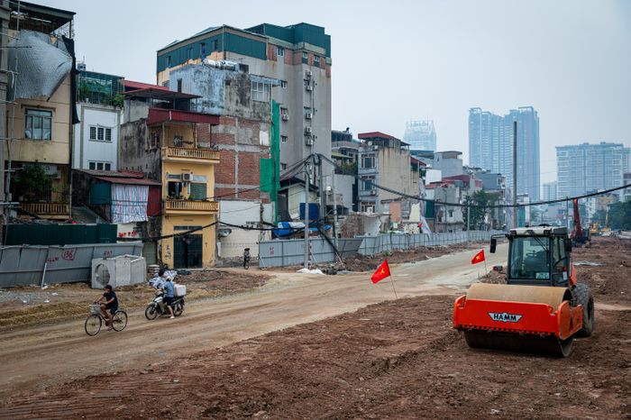  Tại công trường, công nhân và máy móc đang thi công nền đường, cống thoát nước cùng hệ thống hạ tầng kỹ thuật. Người dân vẫn có thể lưu thông qua khu vực này.