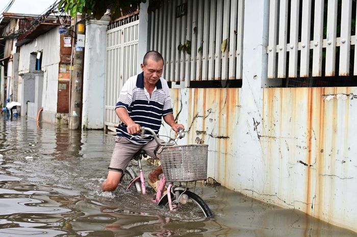  Lo ngại xe máy bị chết máy khi đi qua đoạn đường ngập sâu, một số người dân chọn xe đạp để di chuyển và mua các vật dụng cần thiết. Phương tiện này giúp họ chủ động hơn trong việc đi lại giữa dòng nước, khi nhiều đoạn đường vẫn ngập gần nửa mét. 
