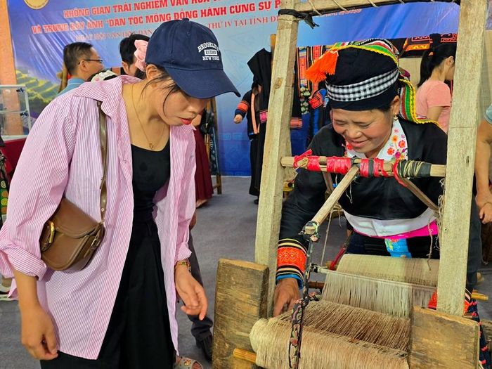 Khách du lịch và người dân tìm hiểu nghề dệt của đồng bào dân tộc Mông tại Ngày hội Văn hóa dân tộc Mông lần thứ IV