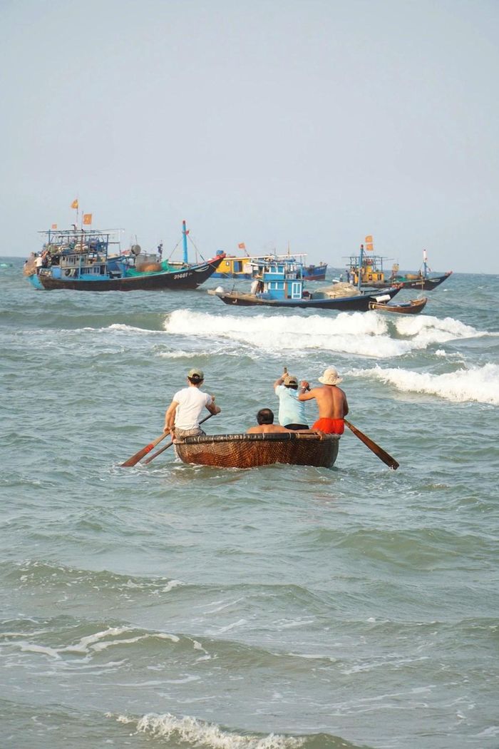 Những người đàn ông làng biển chèo thúng chai tiếp cận tàu đánh bắt, trung chuyển hải sản vào bờ