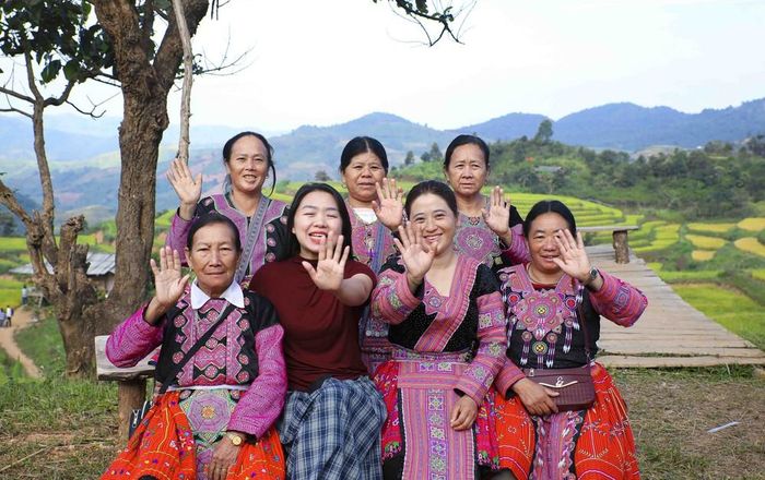 Du khách và đồng bào dân tộc Mông vùng cao mời gọi du khách đến tham quan ruộng bậc thang Pu Nhi. Ảnh: Xuân Tư - TTXVN