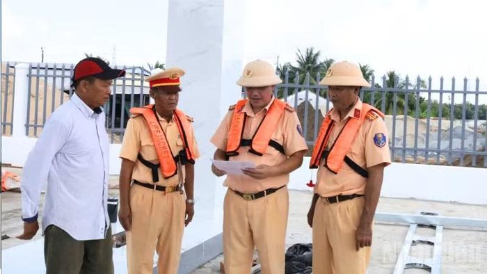 Lực lượng Cảnh sát giao thông đến tận bến bãi tập kết vật liệu xây dựng để tuyên truyền, nhắc nhở chủ doanh nghiệp chấp hành nghiêm quy định. (Ảnh: HOÀI XUYÊN)