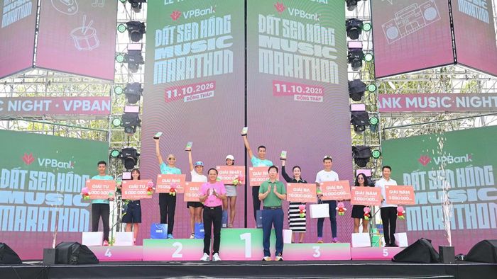 Phó Chủ tịch Ủy ban nhân dân tỉnh Đồng Tháp Huỳnh Minh Tuấn (bìa phải) và lãnh đạo phường Cao Lãnh trao giải cho vận động viên xuất sắc cự ly 42km. (Ảnh: HỮU NGHĨA)