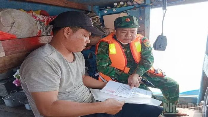 Bộ đội Biên phòng tỉnh Vĩnh Long lập biên bản xử lý tàu đánh cá vi phạm khai thác IUU. (Ảnh: HOÀNG TRUNG)