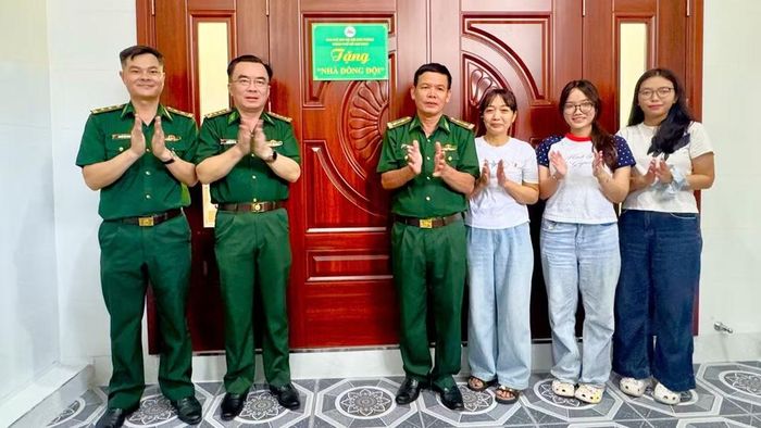 Trung tá Đồng Quang Linh (thứ tư từ phải sang) nhận bàn giao Nhà đồng đội. (Ảnh: QUANG ANH)