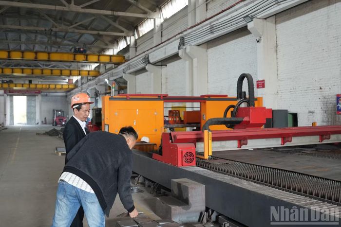 Ông Nguyễn Xuân Huyền giới thiệu về máy móc trong phân xưởng. (Ảnh: THANH THỂ)