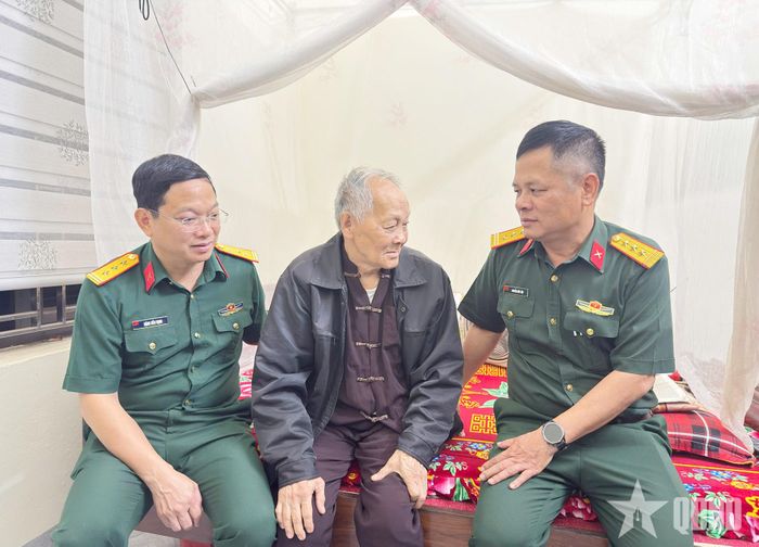 Thượng tá Đặng Tiến Thịnh, Phó chủ nhiệm Chính trị Bộ CHQS tỉnh Tuyên Quang (bên trái) và Thượng tá Nguyễn Hữu Tiệp, Phó đội trưởng Đội tìm kiếm và quy tập hài cốt liệt sĩ (Bộ CHQS tỉnh Tuyên Quang) (bên phải) động viên cụ Trần Văn Sử. Ảnh: ĐÔNG GIANG