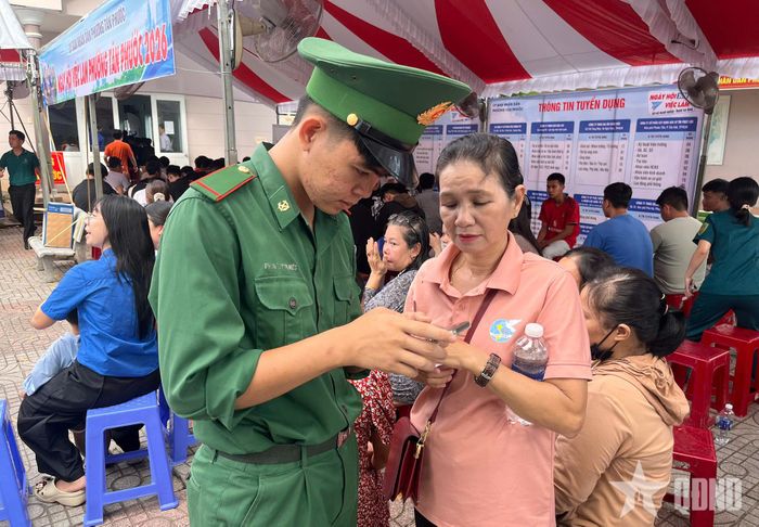Chiến sĩ Đồn Biên phòng Long Sơn hỗ trợ hội viên phụ nữ phường Tân Phước sử dụng các tiện ích số.
