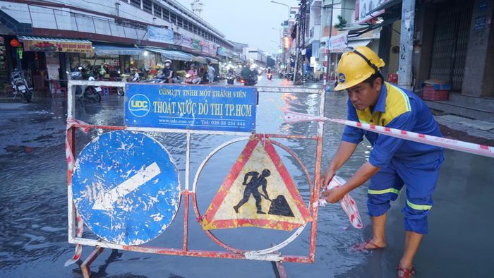  Công ty TNHH MTV Thoát nước đô thị TPHCM rào chắn cảnh báo phương tiện qua lại khu vực ngập sâu ở chợ Thủ Dầu Một. Ảnh: DUY TRẦN 
