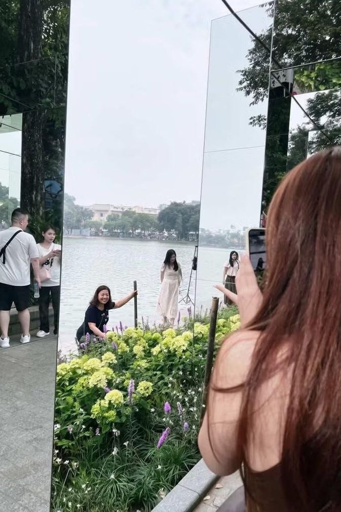 Không ít người dành thời gian căn góc, chụp ảnh cho bạn bè giữa không gian cây xanh, hoa và mặt hồ.