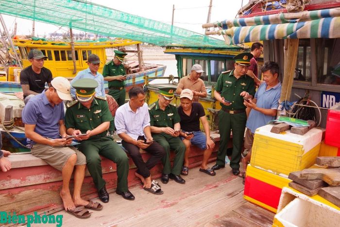 Cán bộ Bộ đội Biên phòng tỉnh Ninh Bình hướng dẫn ngư dân tiếp cận với thông tin pháp luật bằng công nghệ số. Ảnh: Minh Khôi