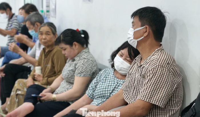 Những gương mặt bệnh nhân mệt mỏi khi ngồi xếp hàng chờ tới lượt vào xạ trị. Ảnh: Khoa Nam