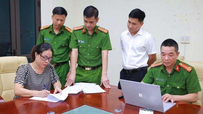Cơ quan công an thi hành lệnh bắt bị can để tạm giam đối với Đặng Thị Lý (áo kẻ ngang).