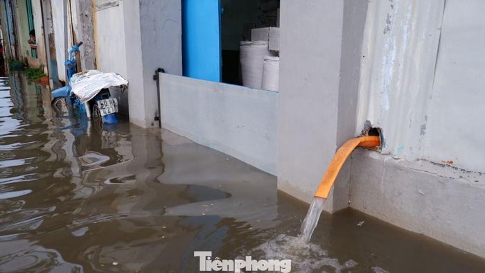 Người dân tại khu dân cư ven đường Rạch Cùng phải lắp tấm chắn và chạy máy bơm để chống ngập.