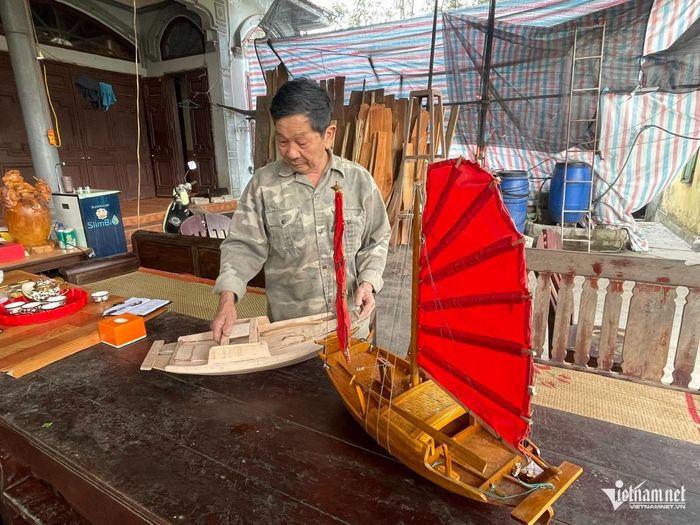 Nghệ nhân Lê Văn Chắn bên chiếc thuyền mô hình bán cho khách du lịch. Ảnh: Mỹ Dung
