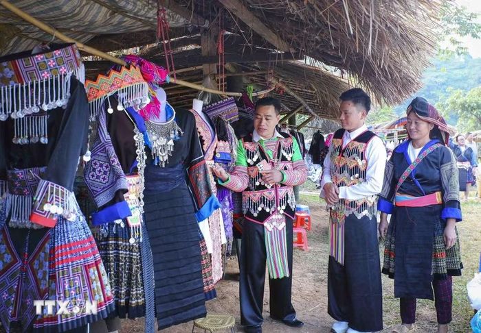 Đồng bào dân tộc Mông giới thiệu, cho thuê trang phục tại khu vực ruộng bậc thang Pu Nhi. (Ảnh: Xuân Tư/TTXVN)