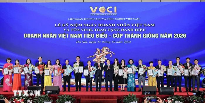 Ông Nguyễn Đức Hiển, Phó Trưởng Ban chính sách, chiến lực Trung ương và ông Hoàng Quang Phòng, Phó Chủ tịch Liên đoàn Thương mại và Công nghiệp Việt Nam (VCCI) trao hoa và bằng khen cho những Doanh nhân xuất sắc. (Ảnh: Lê Đông/TTXVN)
