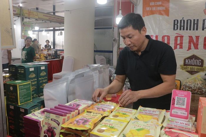 Ông Cường bên cạnh gian hàng hoa quả sấy dẻo - đặc sản Mộc Châu. Ảnh: Phương Thảo